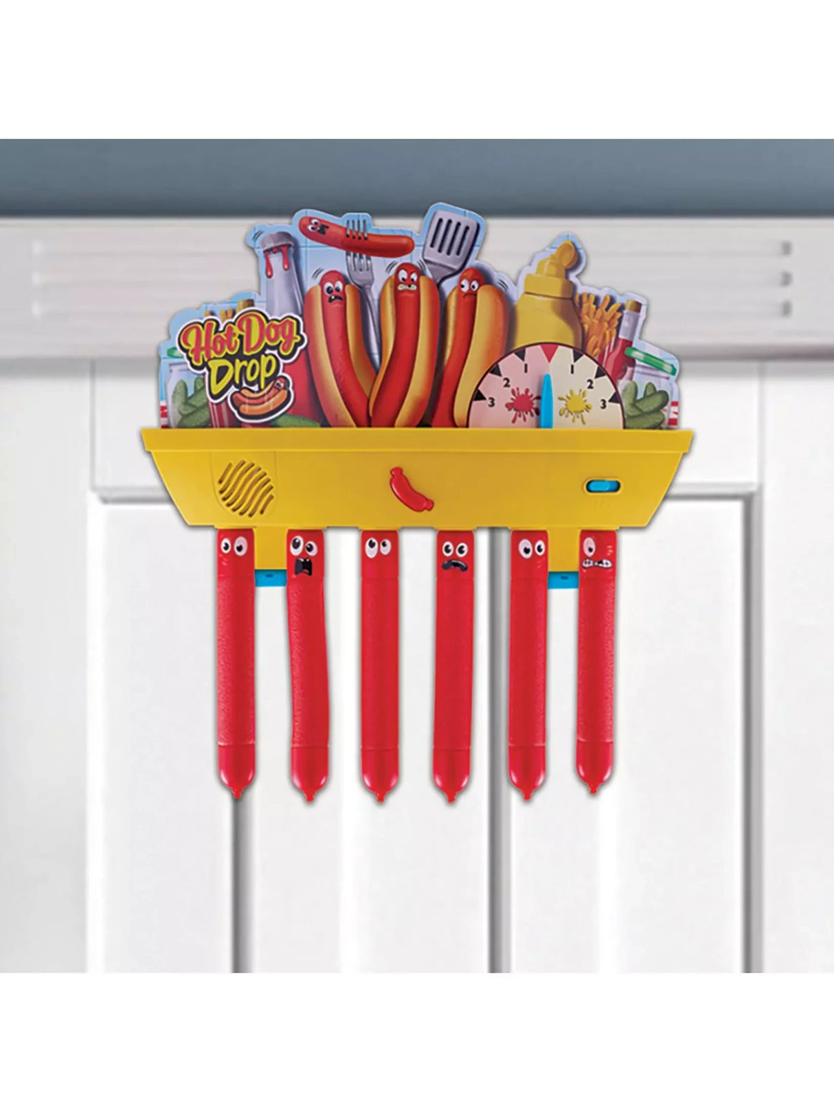 Hot Dog Drop electronic game mounted on a white interior door with six red sausage batons hanging