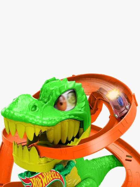 Hot Wheels City T-Rex Fire Station close-up showing the green T-Rex head, teeth, spinning eye and orange track
