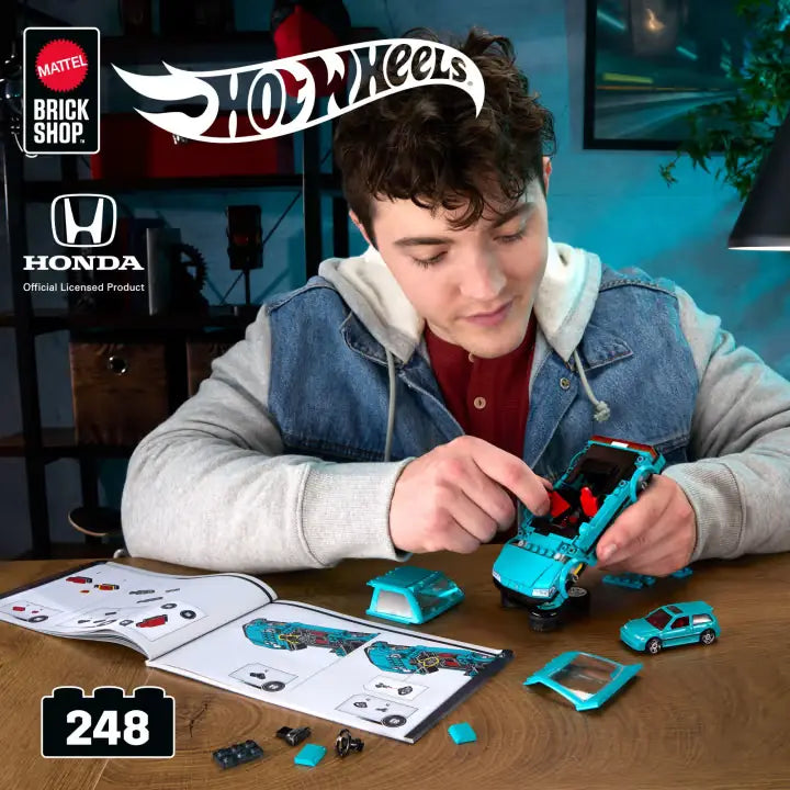 Young builder assembling the turquoise Hot Wheels Custom ’90 Honda Civic EF model with instructions and parts