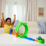 Hot Wheels Monster Trucks Mutant Chaos Loop Challenge assembled on a table with a smiling child raising both arms behind it.