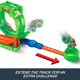 Hot Wheels Monster Trucks Mutant Chaos Loop Challenge with the green and purple monster truck shown at two points along an extended track leading to the green landing cup.