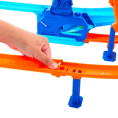 Hand connecting the orange Speed Snap track on the Hot Wheels Rapid Launch Cyclone set