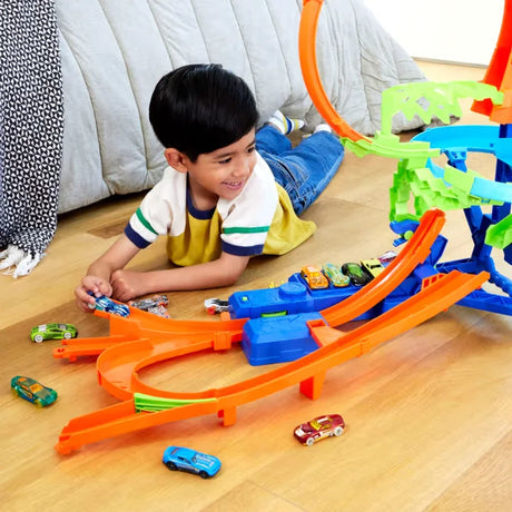 Child playing with Hot Wheels Mid-Air Crash Playset, racing cars toward stunts and crashes in Ireland.