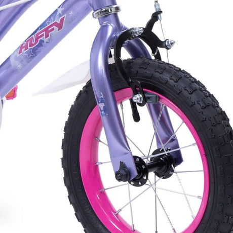 Close up of Huffy So Sweet bike front wheel, pink rim, black tyre, purple fork and front brake