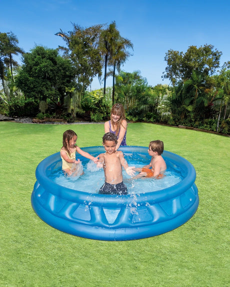Four children playing in a blue Intex Soft Side inflatable pool on grass