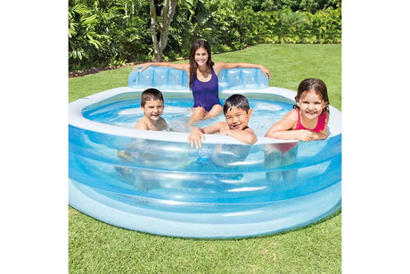 Four children sitting in the Intex Swim Center Family Lounge Pool on grass