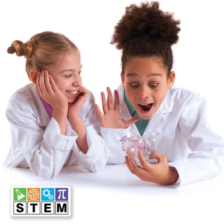 Two children using the John Adams Sparkle Science crystal tree experiment with STEM logo