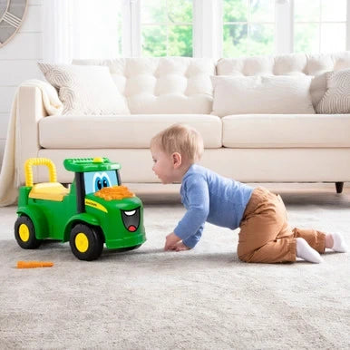 John Deere Johnny Tractor ride on beside child crawling on living room floor