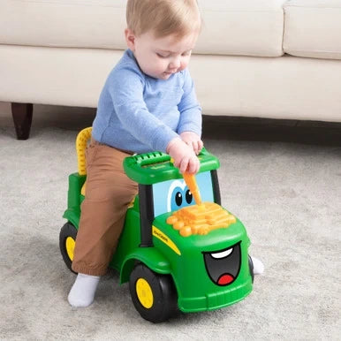 John Deere Johnny Tractor with child seated and holding green steering wheel