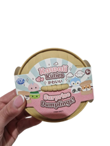 Kawaii Kuties Surprise Dumpling closed dumpling container and product sleeve held in one hand