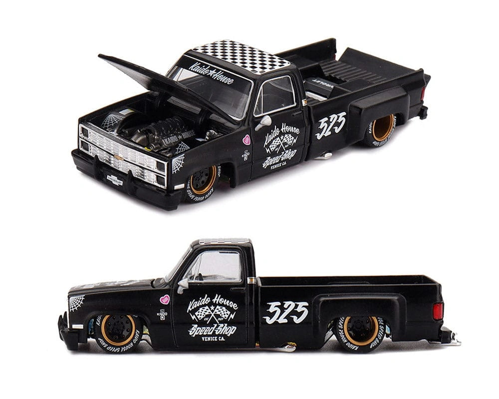 Kaido House Chevrolet Silverado Dually Hot Rod V1 showing front three quarter and side profiles, flat black bodywork, Kaido House Speed Shop door graphics, low suspension and long pickup bed