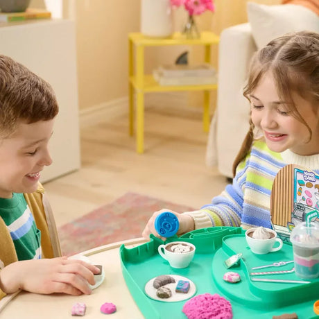 Children playing with Kinetic Sand Café Case, shaping drinks and treats at a table in Ireland.