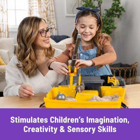 Child playing with Kinetic Sand Construction Site using crane and dump truck on table in Ireland.