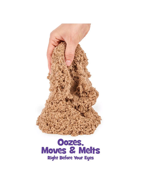 Hand squeezing soft brown Kinetic Sand showing oozing texture – Ireland
