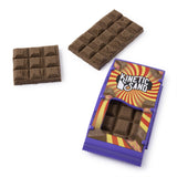 Two brown Kinetic Sand chocolate bar shapes beside a purple wrapper