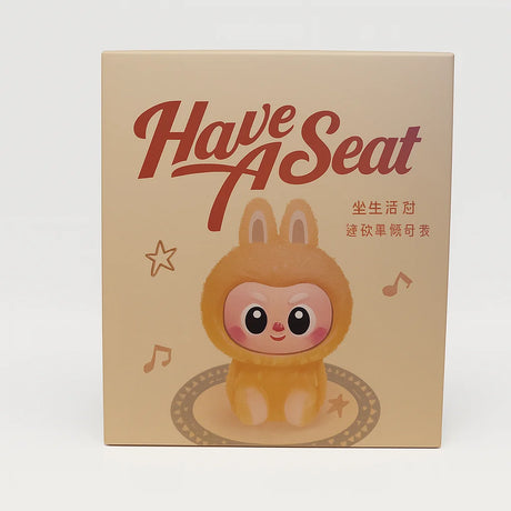 L Monsters collectable toy box featuring a bunny-suited character under the text ‘Have A Seat’ with musical notes and stars – Ireland