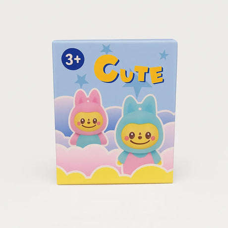 L Monsters collectables packaging box featuring two pastel animal-hooded characters peeking out from pink and yellow clouds under the text ‘CUTE’ on a light gray background.