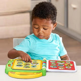 Young boy wearing a turquoise shirt pointing at animal pictures in an open LeapFrog 100 Animals Book on a table