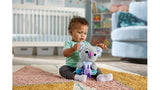Baby sitting on rug holding LeapFrog Cuddle & Learn Koalas plush in nursery setting