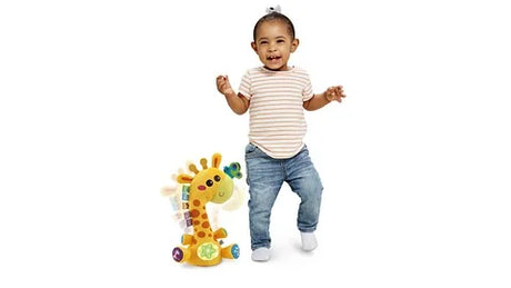 Toddler dancing beside LeapFrog Dancing Colours Giraffe toy with glowing lights – Ireland.