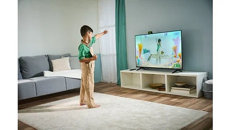 Child learning with LeapFrog LeapMove motion-based educational game on TV in Ireland.