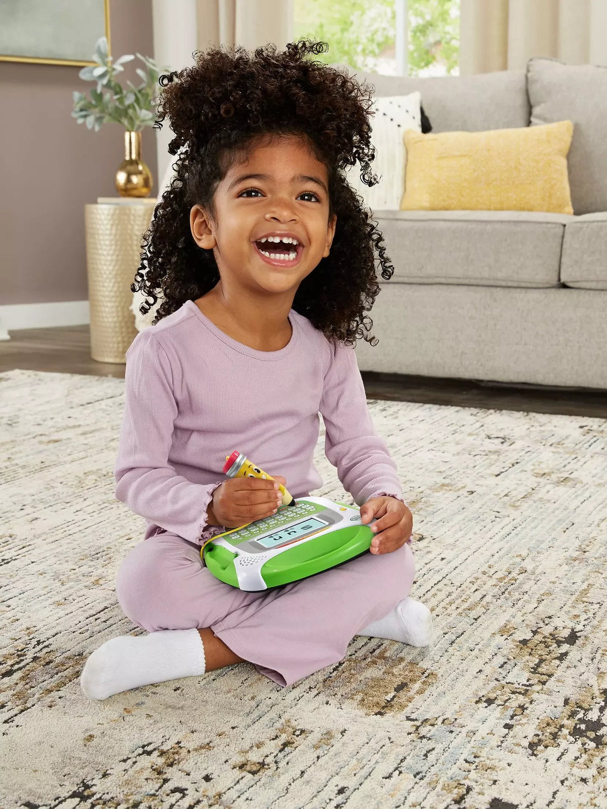Child using the Mr. Pencil stylus with the LeapFrog Scribble, Write & Read learning toy on their lap