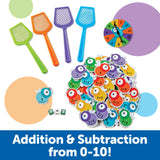 Colourful fly swatters and equation cards laid out beside a number spinner – Ireland