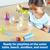 Child using green scooper with sweets and tools on a table – Ireland