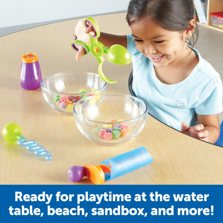 Child using green scooper with sweets and tools on a table – Ireland