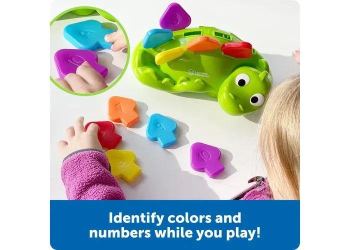 Child playing with Learning Resources Steggy the Fine Motor Dino and coloured numbered scales