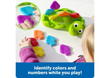 Child playing with Learning Resources Steggy the Fine Motor Dino and coloured numbered scales