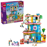 LEGO Friends Heartlake City Friends Club House 42689 retail box displayed beside the completed clubhouse with zip line, slide, minidolls, rooftop drone and tandem bicycle.