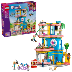 LEGO Friends Heartlake City Friends Club House 42689 retail box displayed beside the completed clubhouse with zip line, slide, minidolls, rooftop drone and tandem bicycle.