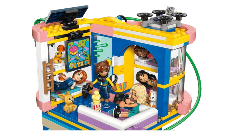 Upper floor of LEGO Friends Heartlake City Friends Club House 42689 showing minidolls relaxing and playing video games, with sofas, gaming controllers, snacks, pets and rooftop drone.