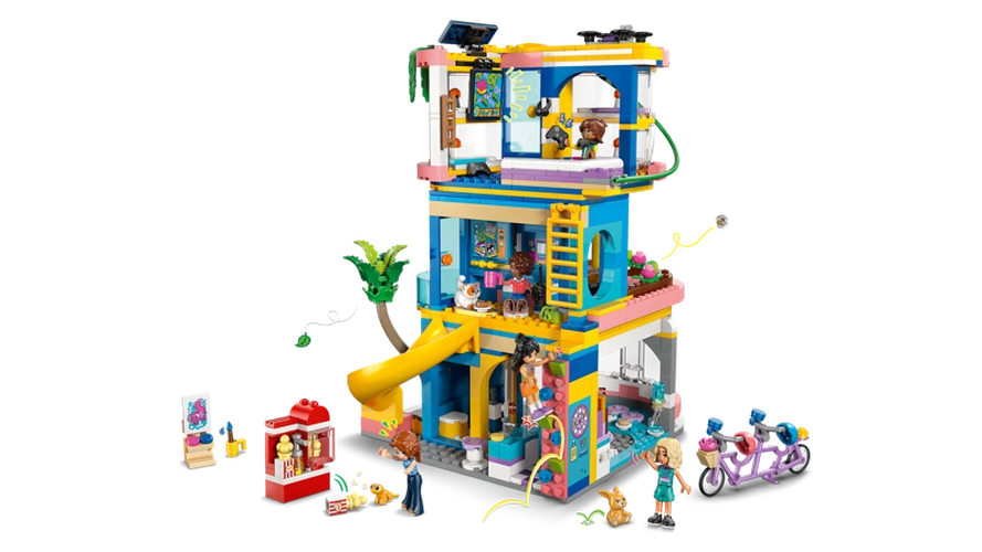 Rear view of LEGO Friends Heartlake City Friends Club House 42689 showing the furnished clubhouse interior, yellow slide, climbing wall, gaming area, minidolls and tandem bicycle.
