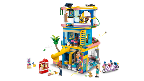 Rear view of LEGO Friends Heartlake City Friends Club House 42689 showing the furnished clubhouse interior, yellow slide, climbing wall, gaming area, minidolls and tandem bicycle.