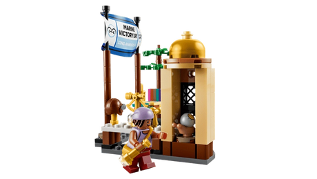 LEGO ONE PIECE Garp's Marine Battleship 75646 market scene featuring a Marine Victory Day anniversary banner, tan market booth, small tree and Usopp minifigure carrying a golden accessory.