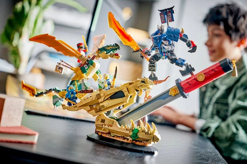 LEGO NINJAGO dragon and mech display model on a table beside a child