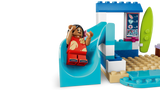 LEGO Lilo figure seated on a blue slide beside a beach sign and surfboard