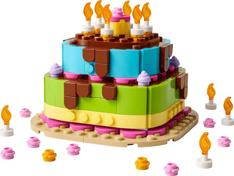 LEGO birthday cake model with candles, pink and yellow decorations and layered cake build