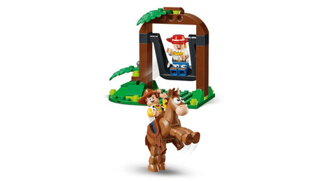 Jessie riding Bullseye in front of the tree swing while Woody sits on the swing on a white background