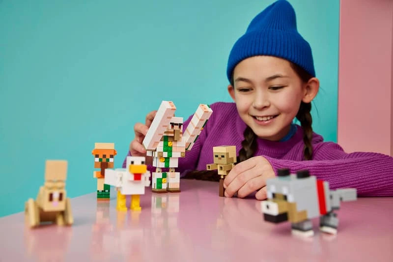 Child playing with LEGO Minecraft iron golem, chicken jockey, wolf, rabbit and villager figures