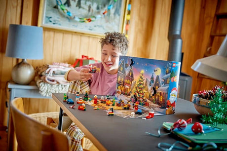 Child reaching toward LEGO City Advent Calendar builds arranged in front of the opened snowy calendar