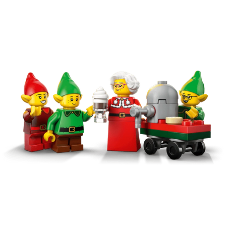 Mrs. Claus and three LEGO elves beside a red and green wheeled cart with a grey machine