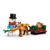 LEGO snowman holding a carrot beside a baby reindeer pulling a red and green sleigh