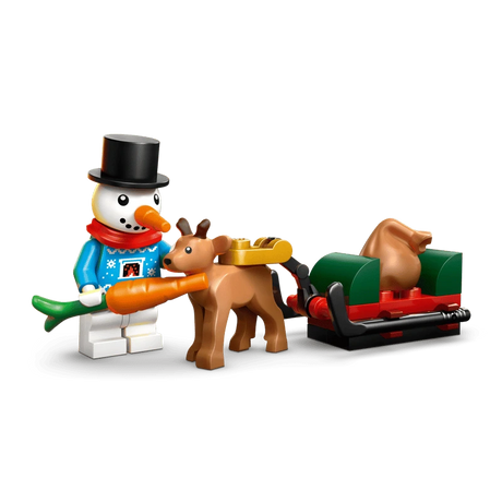 LEGO snowman holding a carrot beside a baby reindeer pulling a red and green sleigh