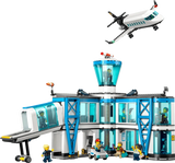 LEGO City airport terminal model with passenger airplane flying above and minifigures around the building