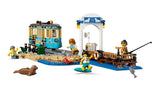 LEGO City beach pier scene with streetcar, station shelter, fishing minifigure, surfer minifigure, surfboard and seal figure