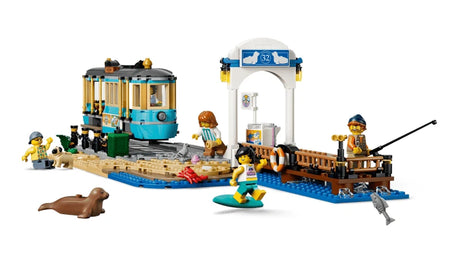 LEGO City beach pier scene with streetcar, station shelter, fishing minifigure, surfer minifigure, surfboard and seal figure