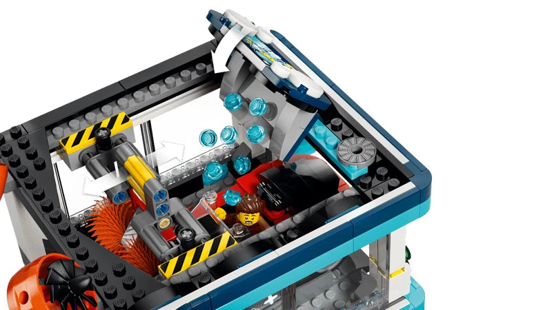 LEGO City drive-through car wash with blue water pieces falling onto a red car between orange brushes
